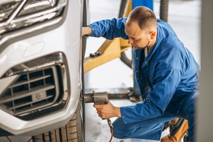 Auto mechanic checking car