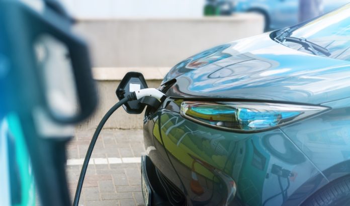 Plugged in charger into an electric car at charge station